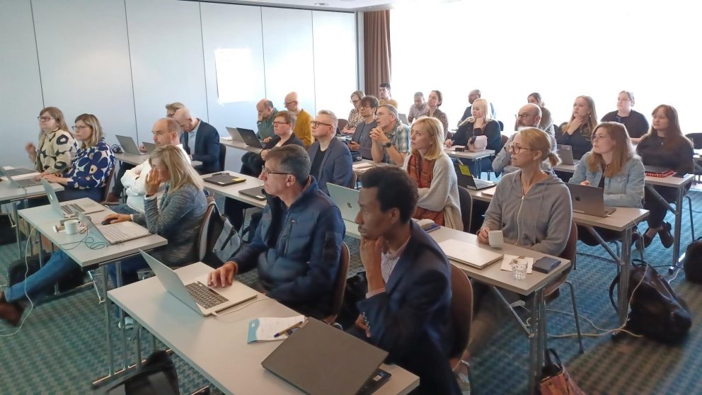 NEMESIS participants in a class room looking torwards the front of the room and listening