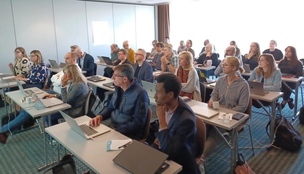 NEMESIS participants in a class room looking torwards the front of the room and listening